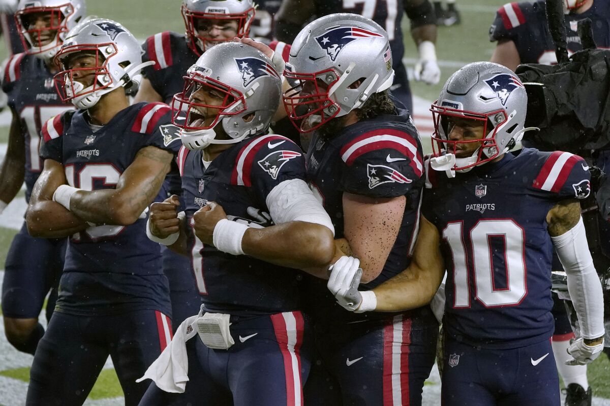 New England Patriots quarterback Cam Newton, center, celebrates his rushing touchdown with teammates in the second half of an NFL football game against the Baltimore Ravens, Sunday, Nov. 15, 2020, in Foxborough, Mass. (AP Photo/Charles Krupa)