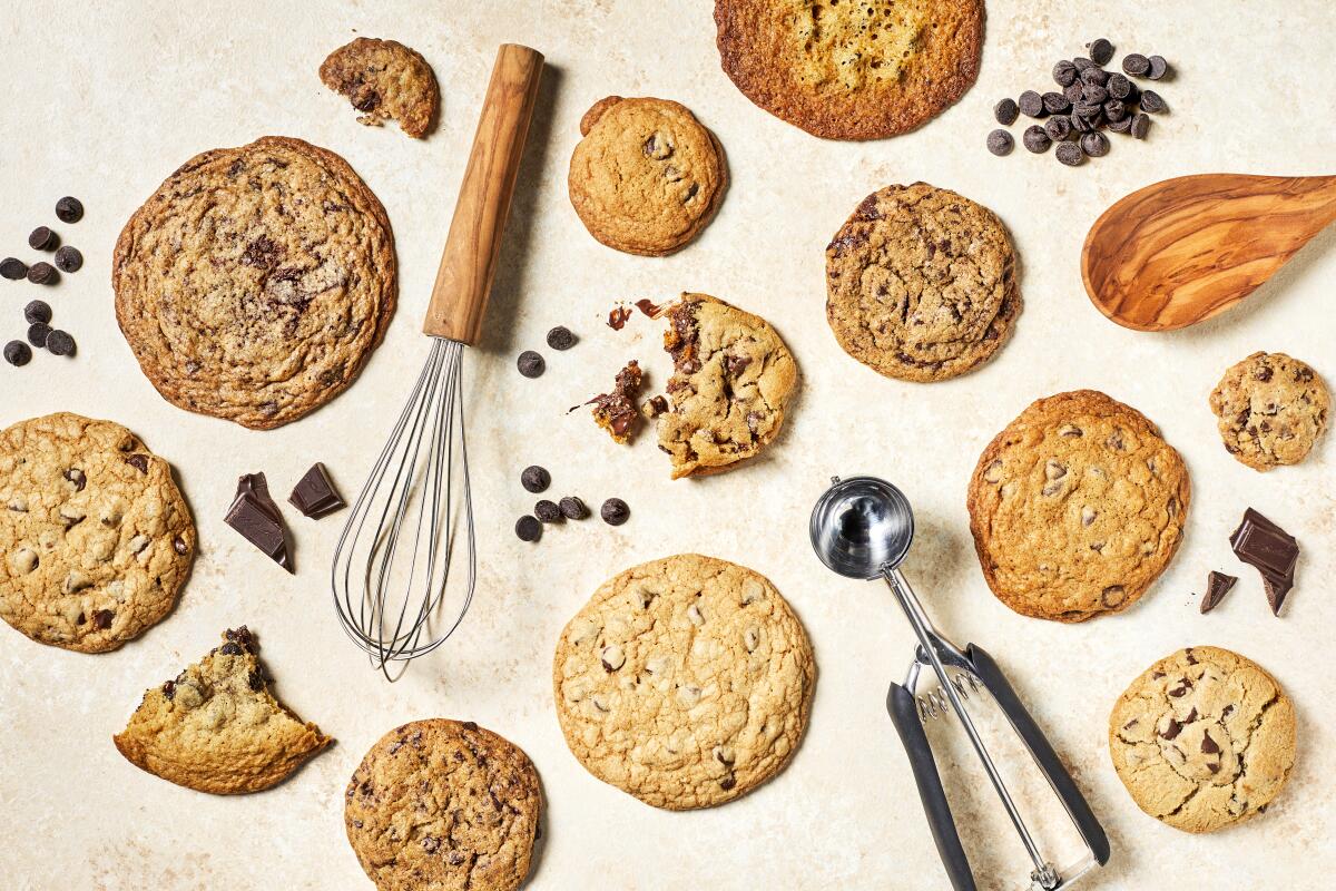 Overhead view of cookies on a table with a whisk, wooden spoon and ice cream scoop.