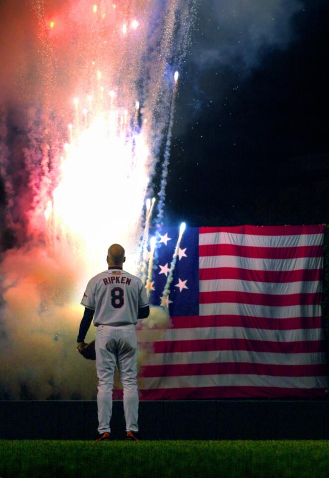 Baltimore, Md.--Oct. 6, 2001 -- Baltimore Orioles third baseman Cal Ripken watches fireworks erupt in colors beside the U.S. flag from Fort McHenry as the Star Spangled Banner plays at Oriole Park at Camden Yards to honor him on his final game before his retirement Sat., Oct. 6, 2001. Ripken played in 3,001 games throughout his career, with a lifetime .276 batting average. (Baltimore Sun/Karl Merton Ferron) ELECTRONIC IMAGE (DSC_0111.JPG)