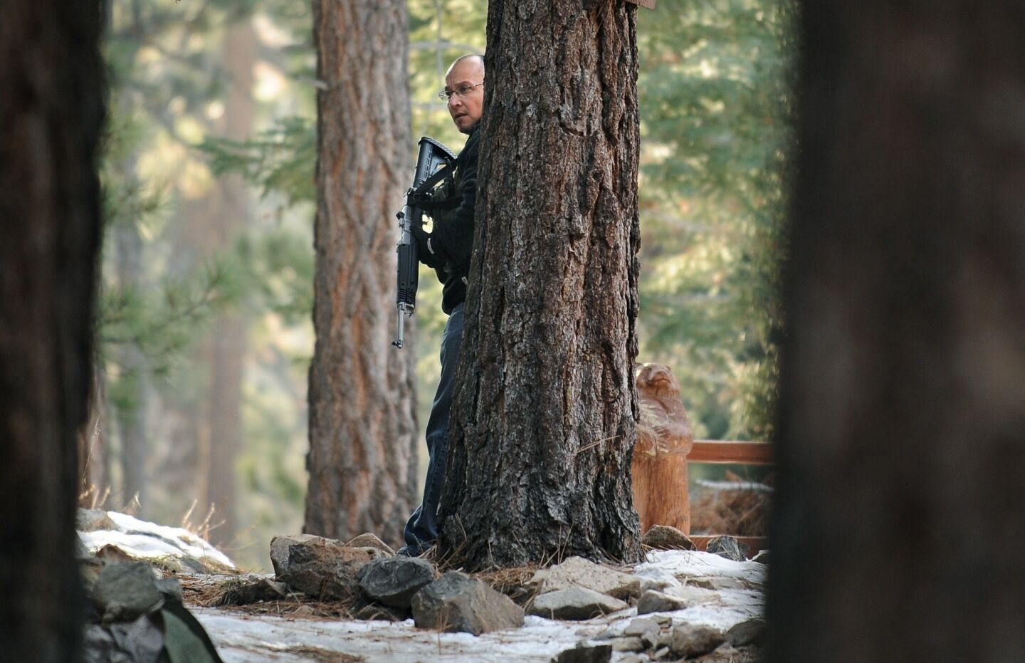 A San Bernardino County sheriff's officer searches for shooting suspect Christopher Dorner in Big Bear Lake.