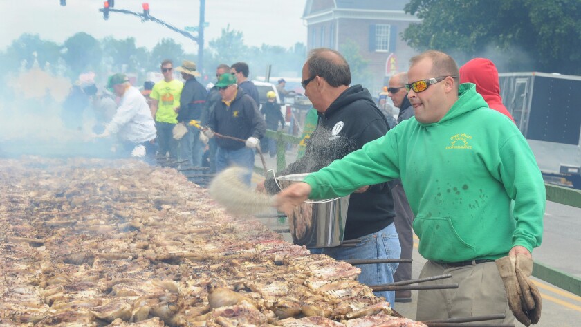 Team members throw salt and pepper on chicken grilling on the pits at the International Bar-B-Q Festival in Owensboro, Ky., on May 14.