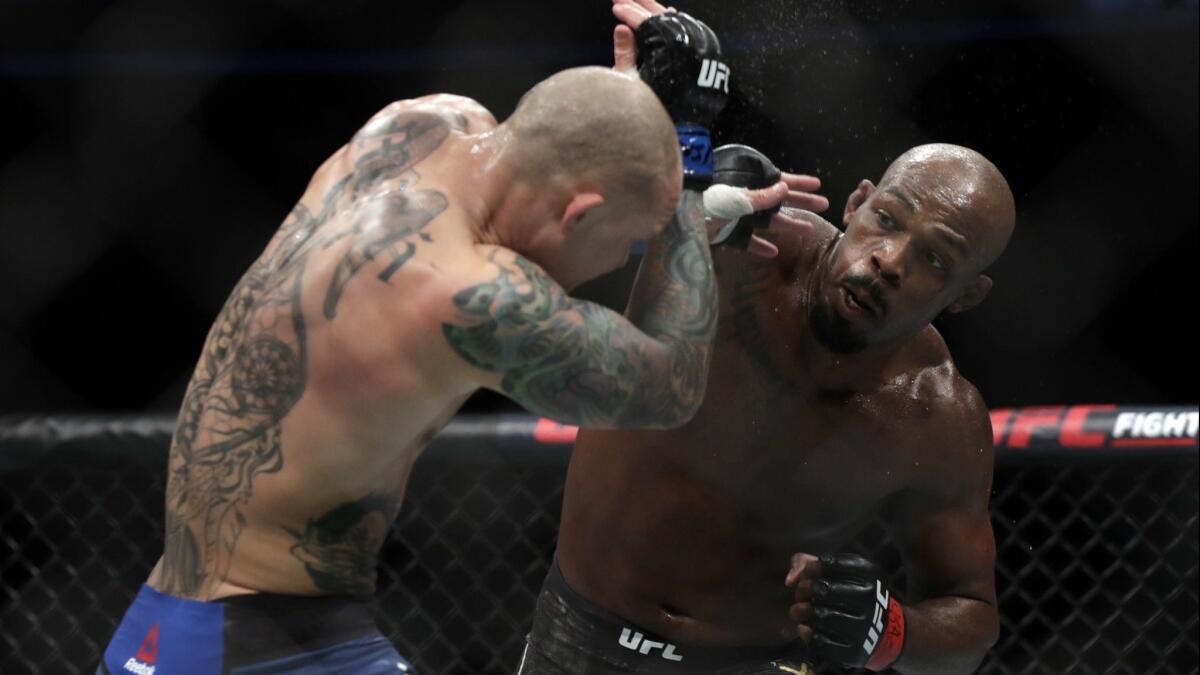 Jon Jones delivers a blow while fighting Anthony Smith during the light-heavyweight title fight at UFC 235 on Saturday.