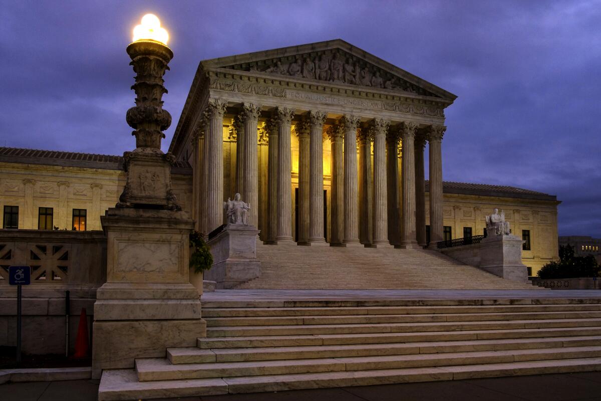 The Supreme Court building illuminated at dusk