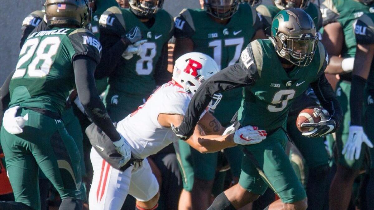 Michigan State safety Montae Nicholson intercepts a pass in the second half and avoids a tackle during a 49-0 blowout of Rutgers.