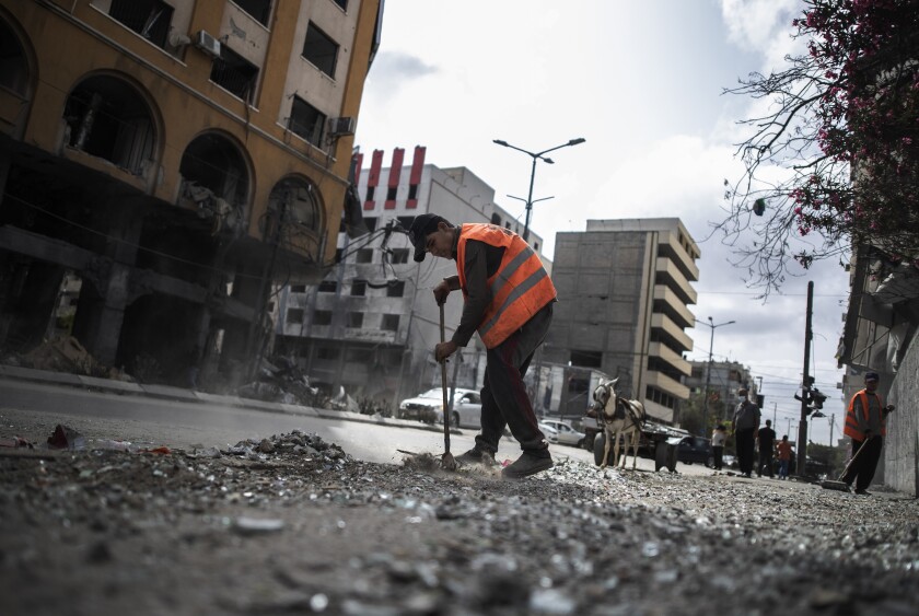 Worker sweeping street in Gaza City.