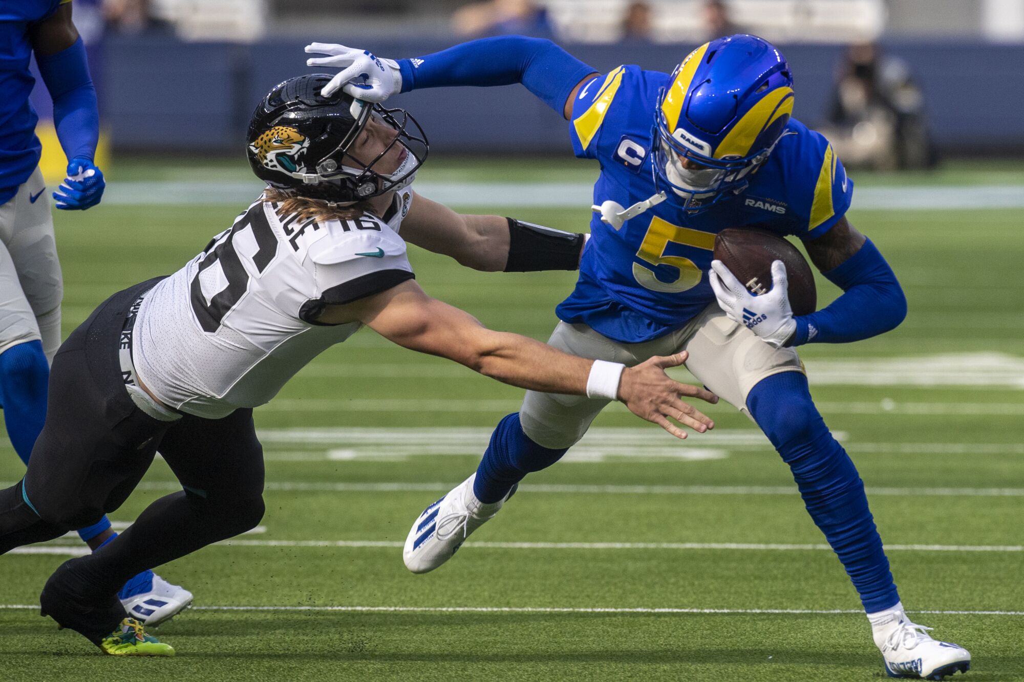 Rams cornerback Jalen Ramsey, right, picks up a fumble by Jacksonville Jaguars quarterback Trevor Lawrence.