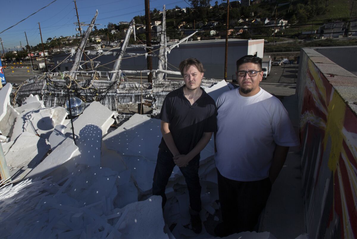Ovelmen, left, with street artist Mondo Bobadilla, on the roof of AWOL gallery, with a sculpture inspired by Ernest Shackleton's ship, the Endurance.