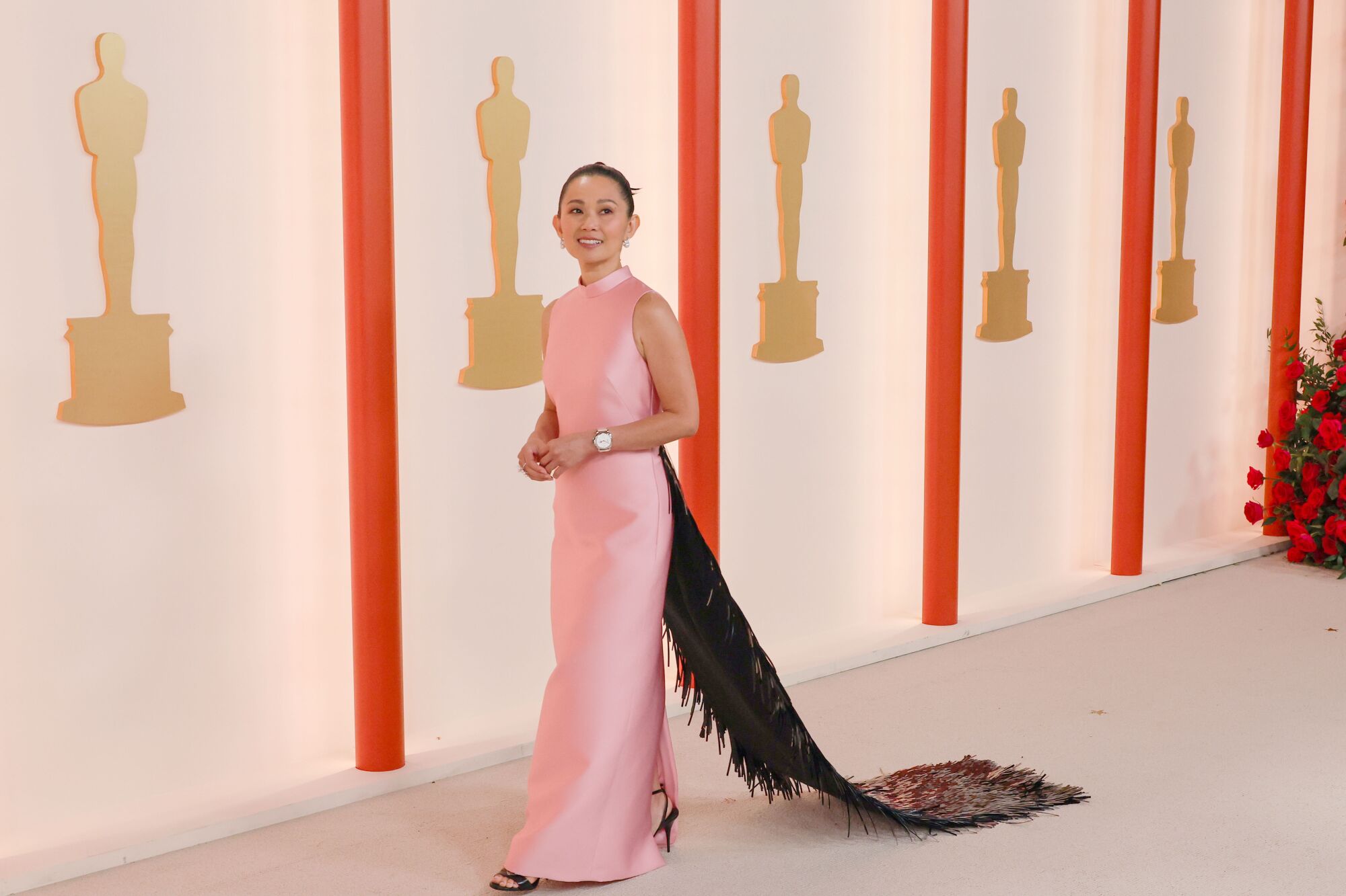 Hong Chau in a pink gown with a darker colored, fringed train.