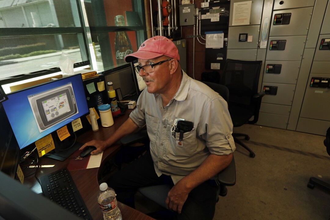 Michael Dray sits in front of computer screens