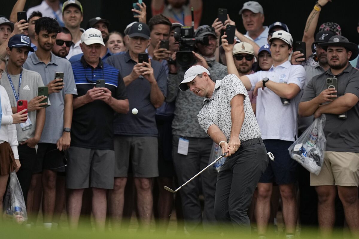 Rory McIlroy, of Northern Ireland, center, chips to the green on the sixth hole during the second round of the Dell Technologies Match Play Championship golf tournament in Austin, Texas, Thursday, March 23, 2023. (AP Photo/Eric Gay)