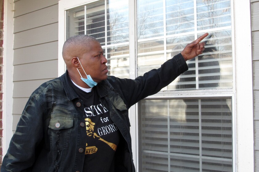 LaTonya Floyd, the older sister of George Floyd, gestures towards a bullet hole in the window of her apartment, Thursday, Jan. 6, 2022, in Houston, as she discussed the New Year’s Day shooting that wounded her and her brother’s 4-year-old grandniece, Arianna Delane. Arianna remained hospitalized on Thursday as she was shot in her side and the bullet pierced her liver and lungs and broke three ribs. (AP Photo/Juan A. Lozano)