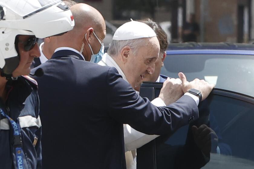 Pope Francis stops to greet police that escorted him as he arrives at the Vatican after leaving the hospital on his Ford, 10 days after undergoing planned surgery to remove half his colon Wednesday, July 14, 2021. Francis had half of his colon removed for a severe narrowing of his large intestine on July 4, his first major surgery since he became pope in 2013. (AP Photo/Riccardo De Luca)