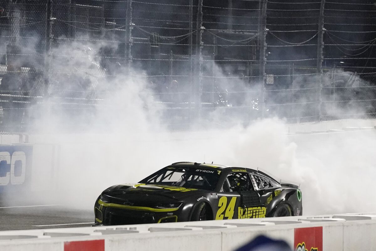 William Byron (24) does a burnout after he won the NASCAR Cup Series auto race at Martinsville Speedway on Saturday, April 9, 2022, in Martinsville, Va. (AP Photo/Steve Helber)