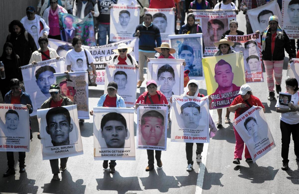 Protesters last month carry photos of some of the 43 college students who disappeared in the Mexican state of Guerrero in September.