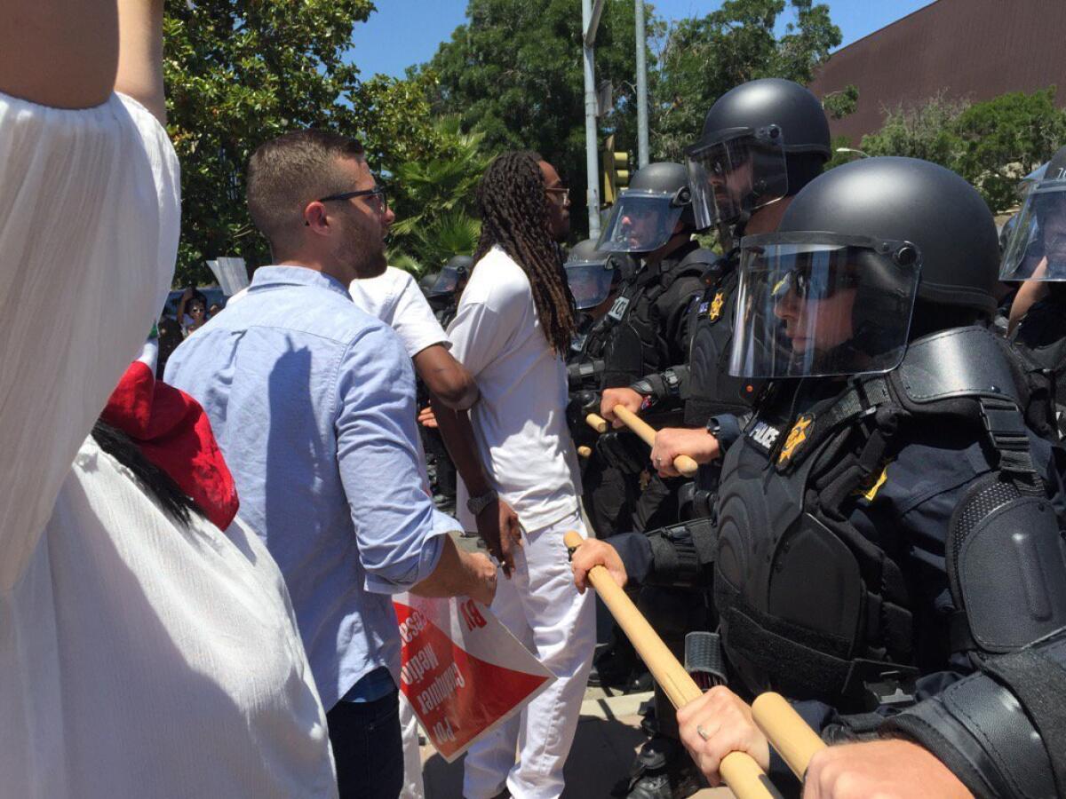 Police and protesters face off in Fresno near the site of a Trump rally.