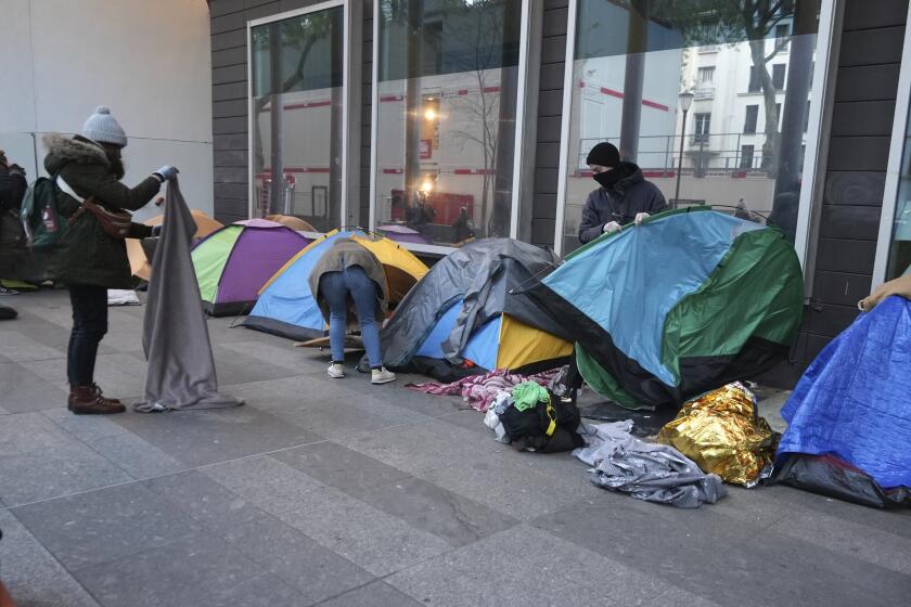 Activistas ayudan a migrantes a empacar sus pertenencias en un campamento improvisado el martes 23 de abril en París, Francia. La policía francesa desalojó el martes a varios migrantes de un campamento improvisado en París a unos pasos del río Sena, una nueva operación en lo que grupos de ayuda describen como una campaña de “limpieza social” antes de los Juegos Olímpicos. (AP Foto/Nicolas Garriga)