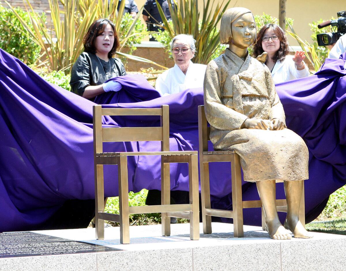 Bok-dong Kim, a comfort woman survivor, is directly behind the monument as it is being unveiled at the unveiling ceremony of the Comfort Women Memorial Monument in Glendale on Tuesday, July 30, 2013.