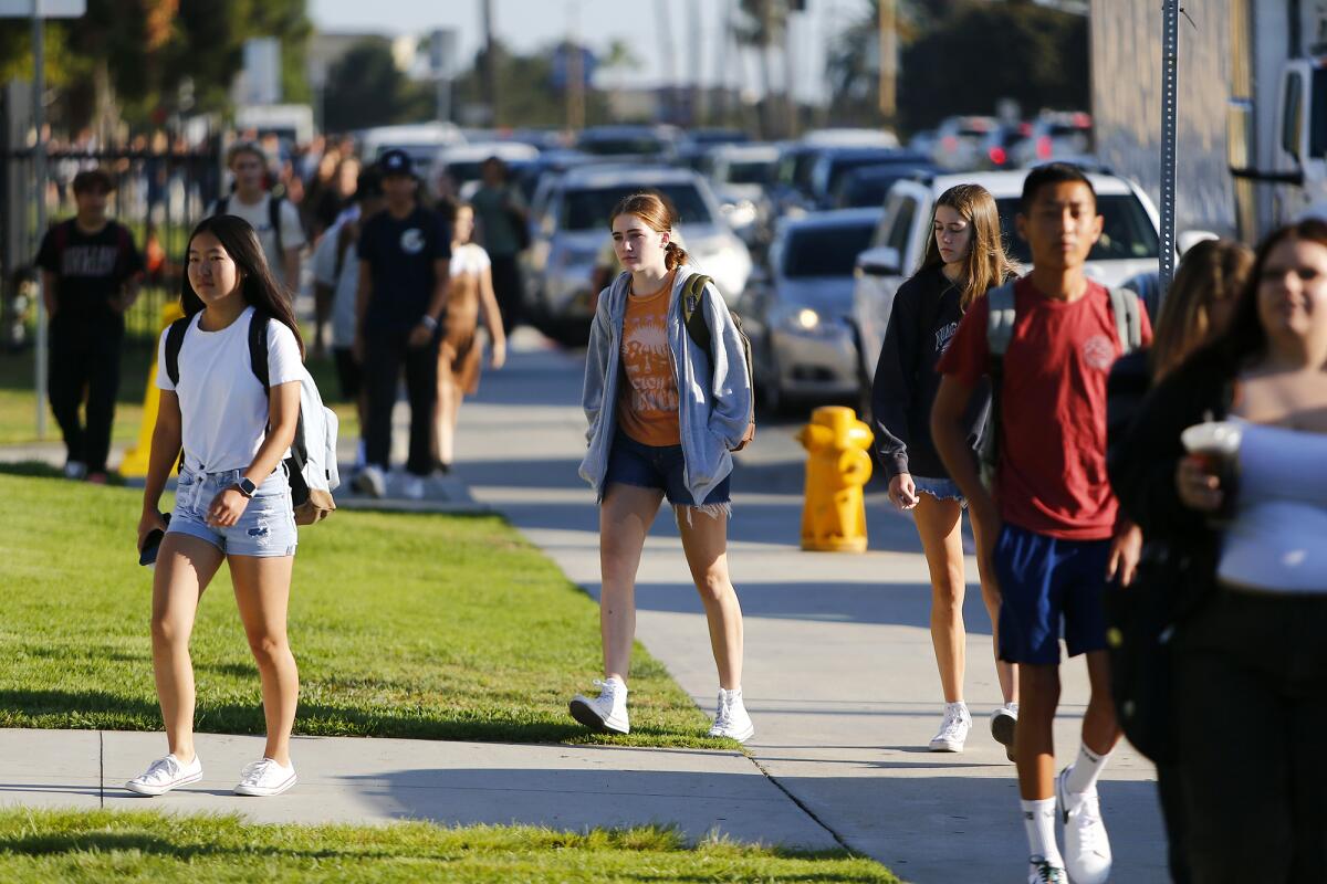 Students walk to campus during the first day of school at Huntington Beach High on Wednesday.