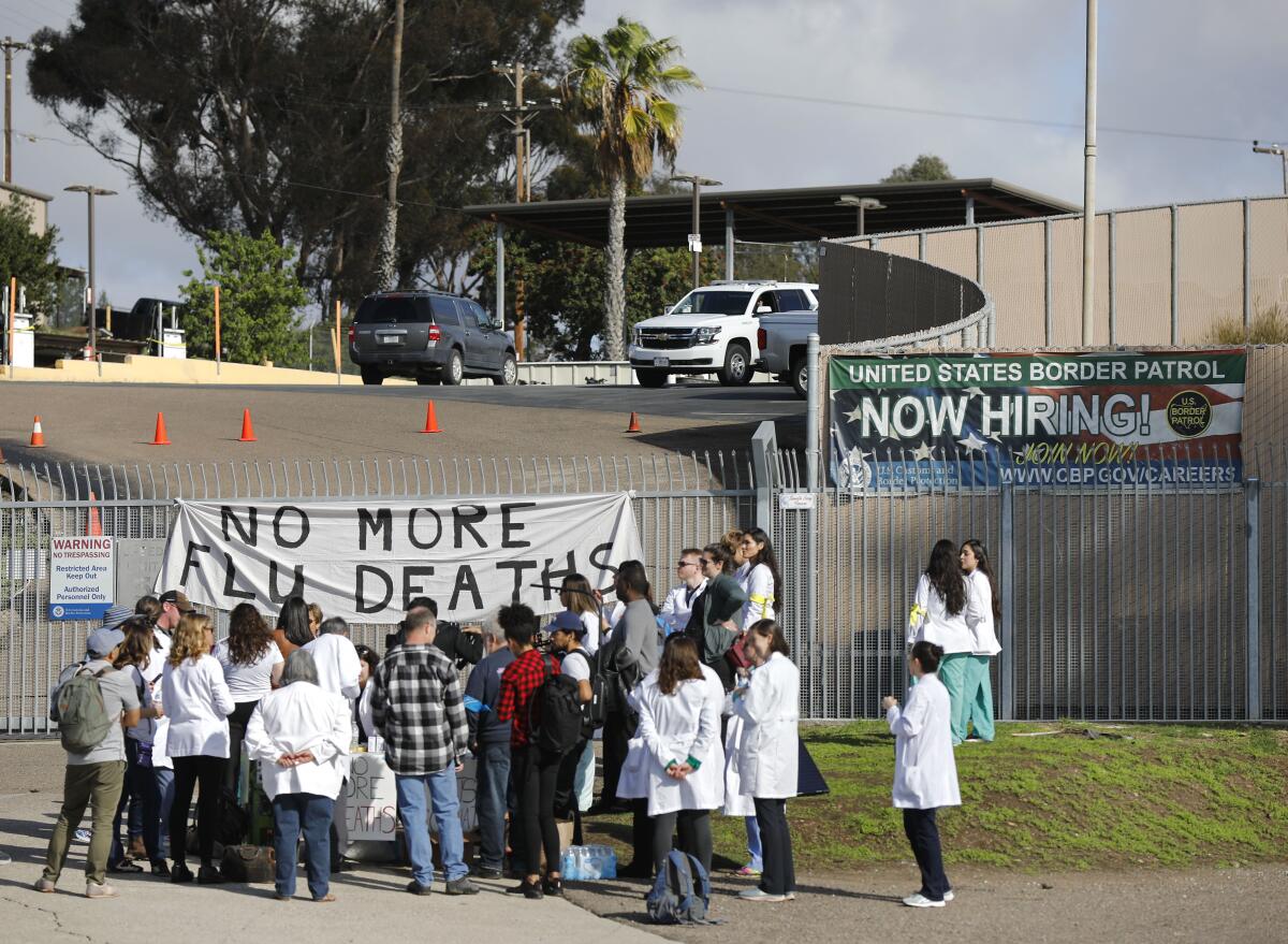 Doctores y otros proveedores de atención médica de Doctors for Camp Closure se encuentran frente a la Estación de Patrulla Fronteriza en San Ysidro con la esperanza de tener acceso a las instalaciones para vacunar a los migrantes detenidos el 9 de diciembre de 2019.