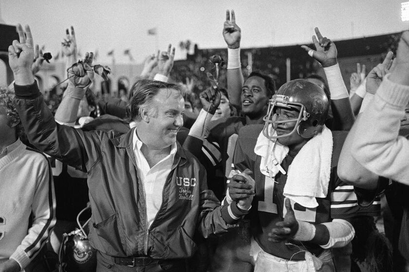 USC Trojans coach John Robinson congratulates his player Charles White (12) after they trounced UCLA to win their berth in the Rose Bowl in Los Angeles, Calif., Nov. 24, 1979. White ran for 194 yards and four touchdowns to lead his team to a 49-14 victory. over UCLA. (AP Photo/Lennox McLendon)