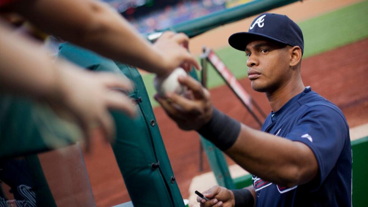 Braves infielder Hector Olivera returns a ball to a fan as he signs autographs before a game on Sept. 5.