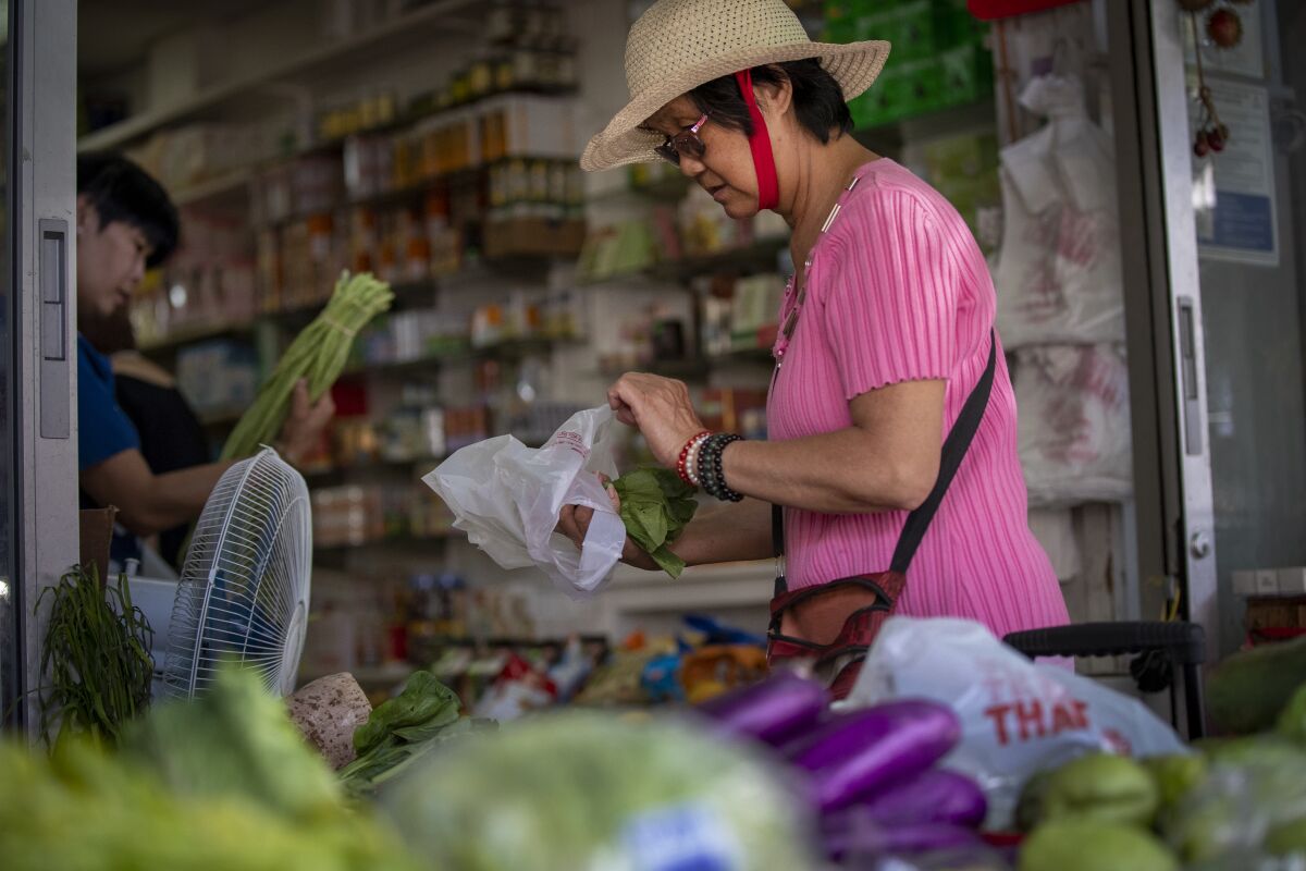 Customer selects yu choy at Yue Wa Market in Chinatown