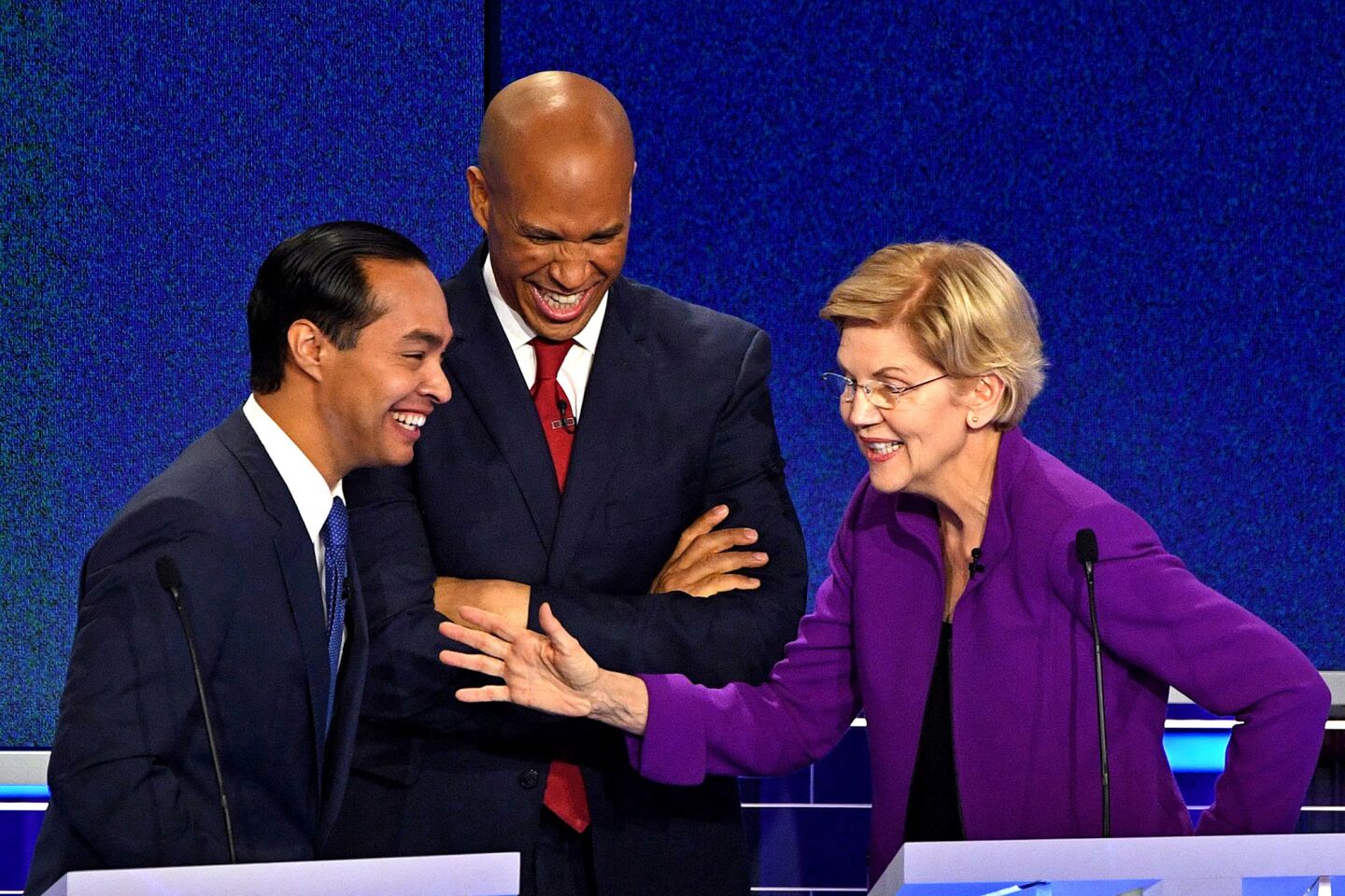 Democratic presidential hopefuls (fromL) Former US Secretary of Housing and Urban Development Julian Castro, US Senator from New Jersey Cory Booker and US Senator from Massachusetts Elizabeth Warren laugh during a break in the first Democratic primary debate of the 2020 presidential campaign season hosted by NBC News at the Adrienne Arsht Center for the Performing Arts in Miami, Florida, June 26, 2019.