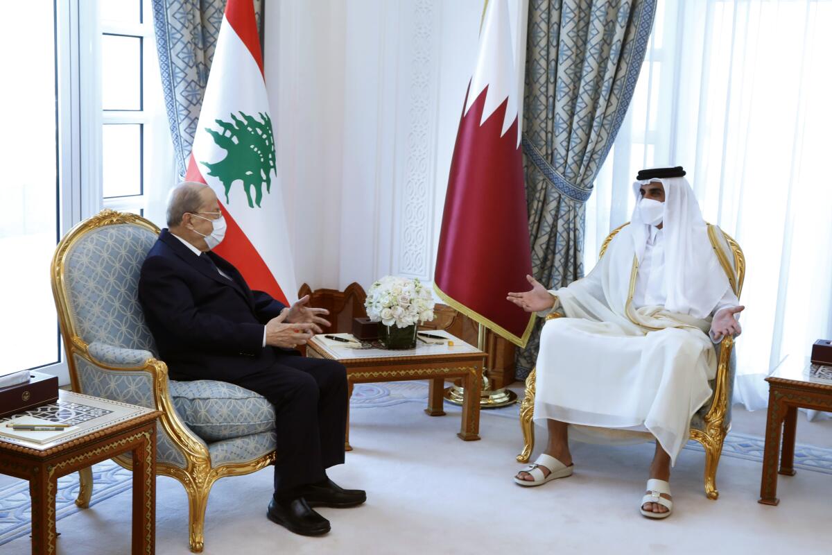 In this photo released by Lebanese government, Qatar's Emir Sheikh Tamim bin Hamad Al Thani, right, meets with Lebanese President Michel Aoun, in Doha, Qatar, Monday, Nov 29, 2021. Aoun arrived in Qatar Monday for the opening ceremony of an Arab soccer tournament amid - and for talks on an precedented diplomatic crisis between Beirut and oil-rich Gulf nations. (Dalati Nohra/Lebanese Official Government via AP)