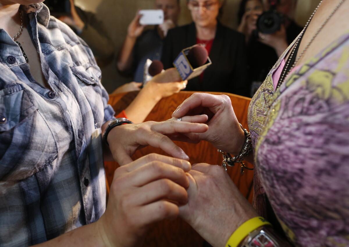 Jill Winkler, left, and Pamela Dietzler exchange rings as they are married at the Milwaukee County Courthouse.