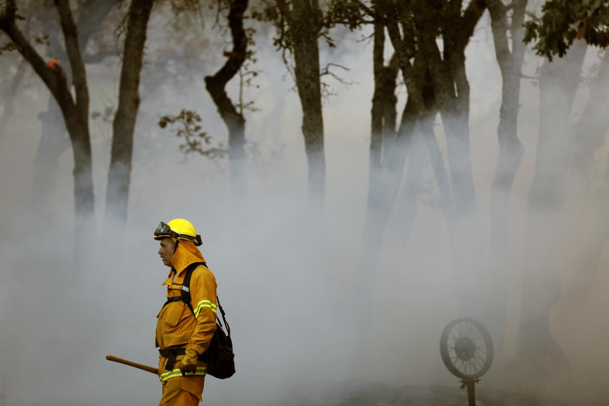 Volunteer firefighter Michael Simon is surrounded by smoke while working a fire in the Oakmont community.