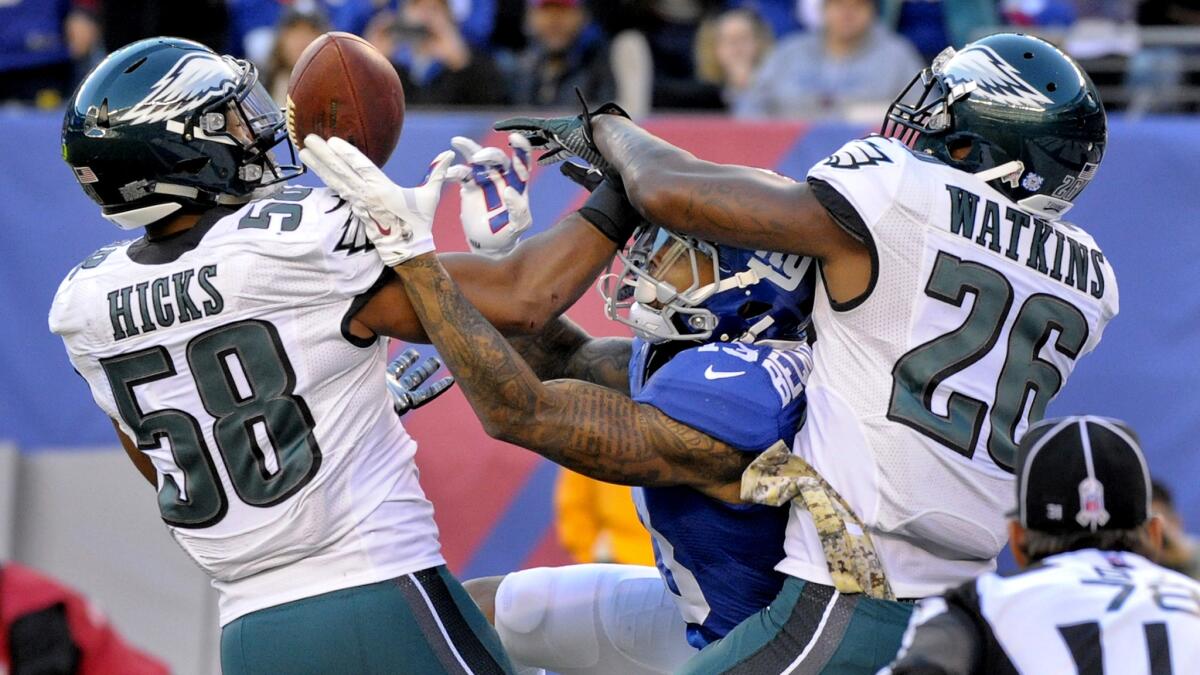 Giants wide receiver Odell Beckham Jr. tries to make a catch in the end zone but Eagles linebacker Jordan Hicks (58) and defensive back Jaylen Watkins (26) break up the pass during the third quarter Sunday.