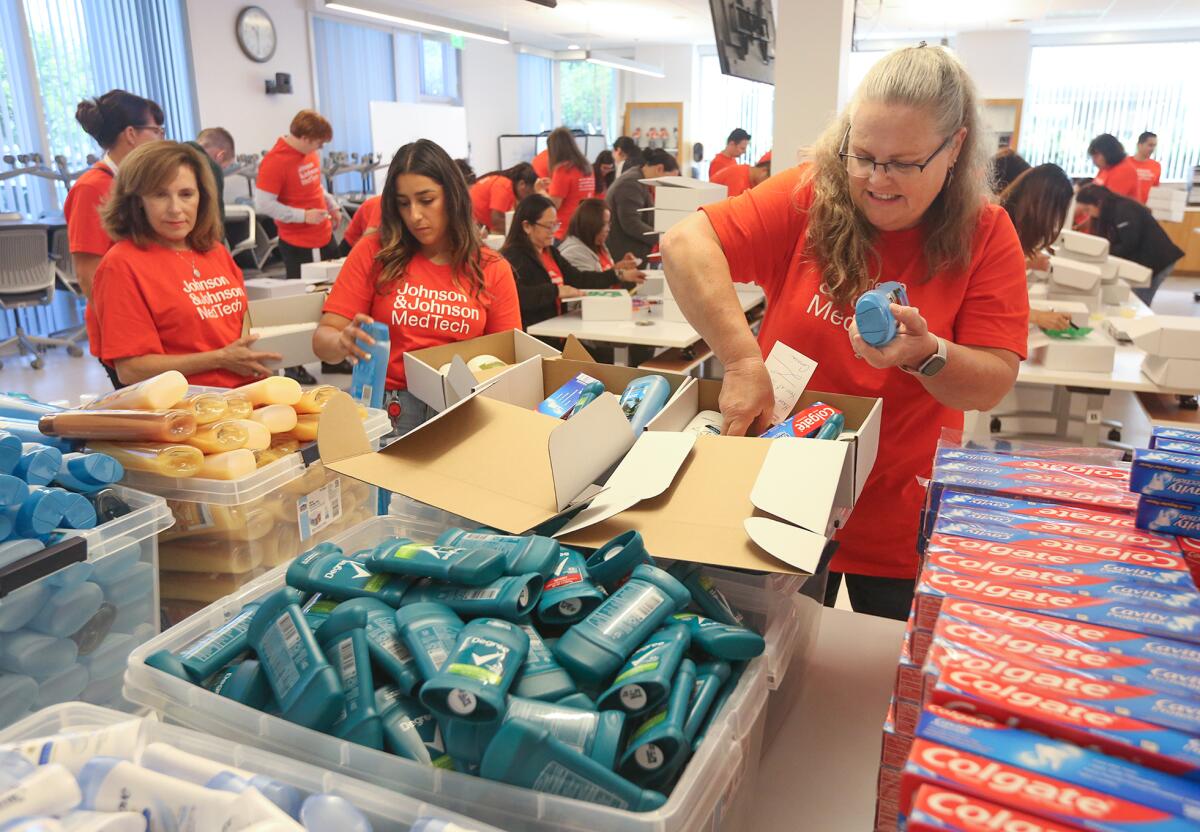 Volunteer Wendy Cardinale, a senior manager, right, fills two hygiene kits.