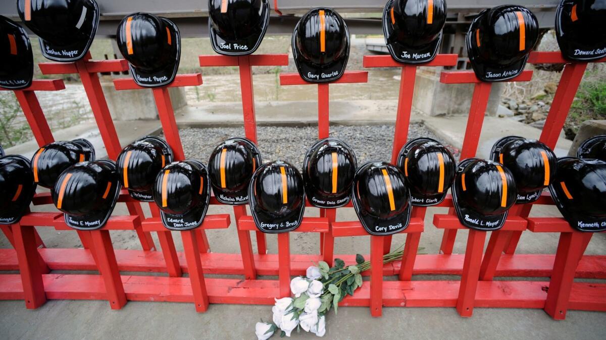 Cascos y cruces pintadas en la entrada de la mina de carbón Upper Big Branch, de Massey Energy, en Montcoal, Virginia Occidental. El monumento representa a los 29 mineros que murieron en una explosión en el lugar (Jeff Gentner / Associated Press).