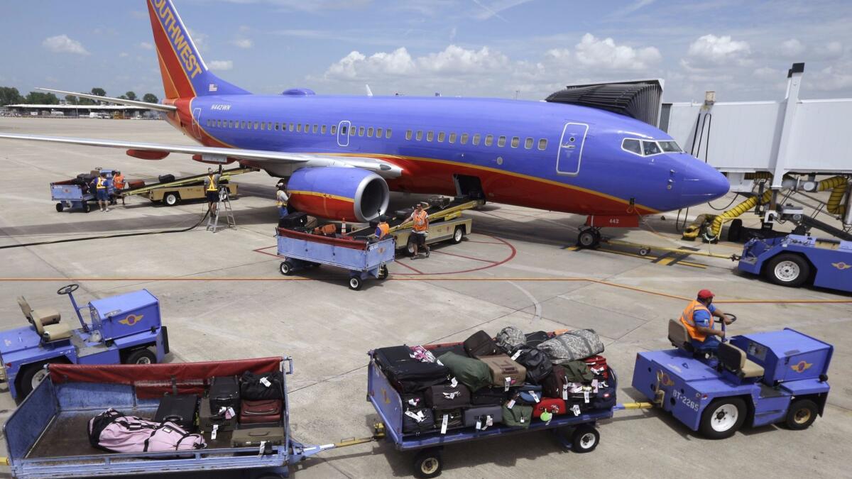 Baggage carts are towed to a Southwest Airlines jet at Bill and Hillary Clinton National Airport in Little Rock, Ark. The CEO of the airline said he will not consider charging a bag fee to raise revenues.