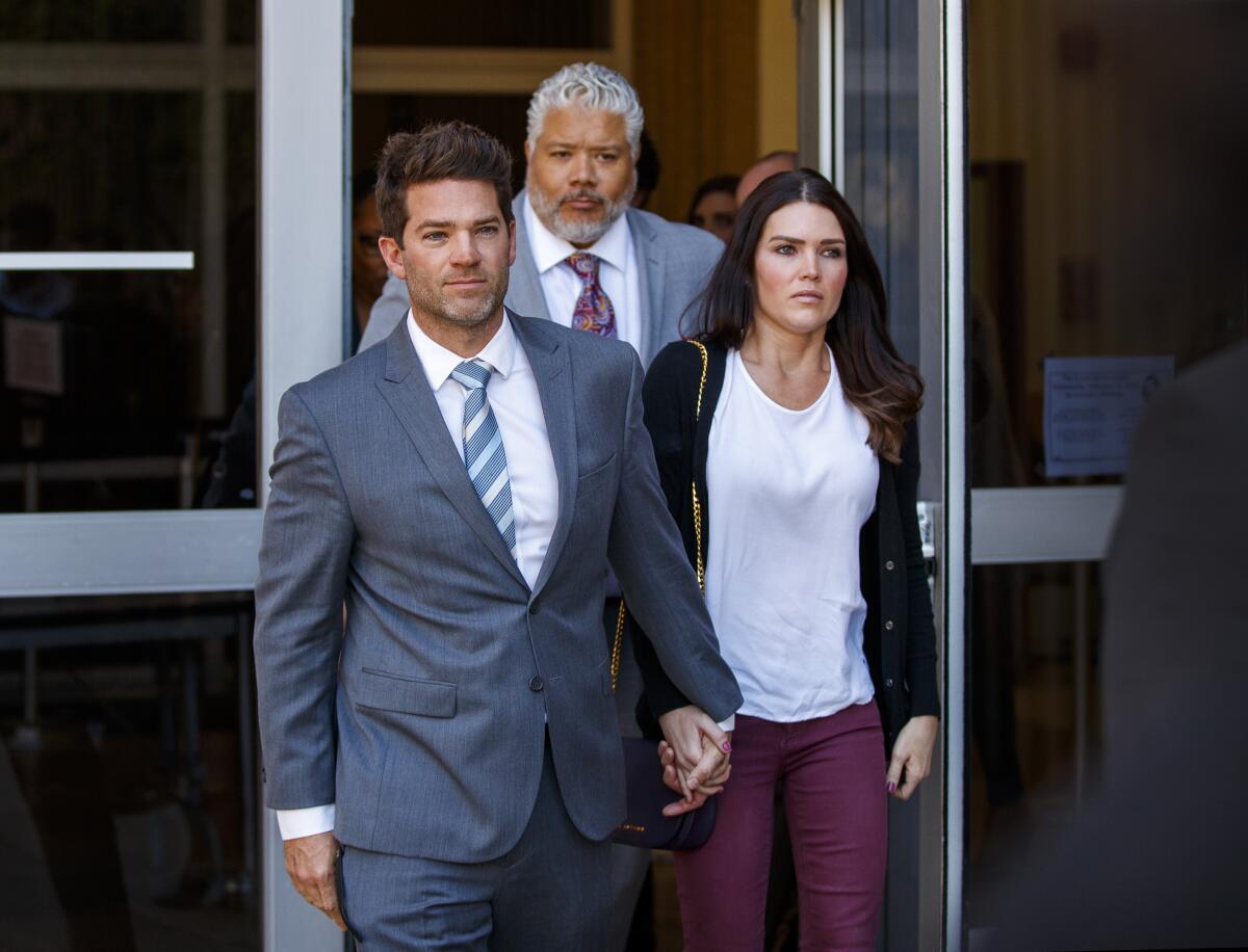 Newport Beach surgeon Grant Robicheaux, center, and his girlfriend Cerissa Riley leave the Harbor Justice Center in 2020. 