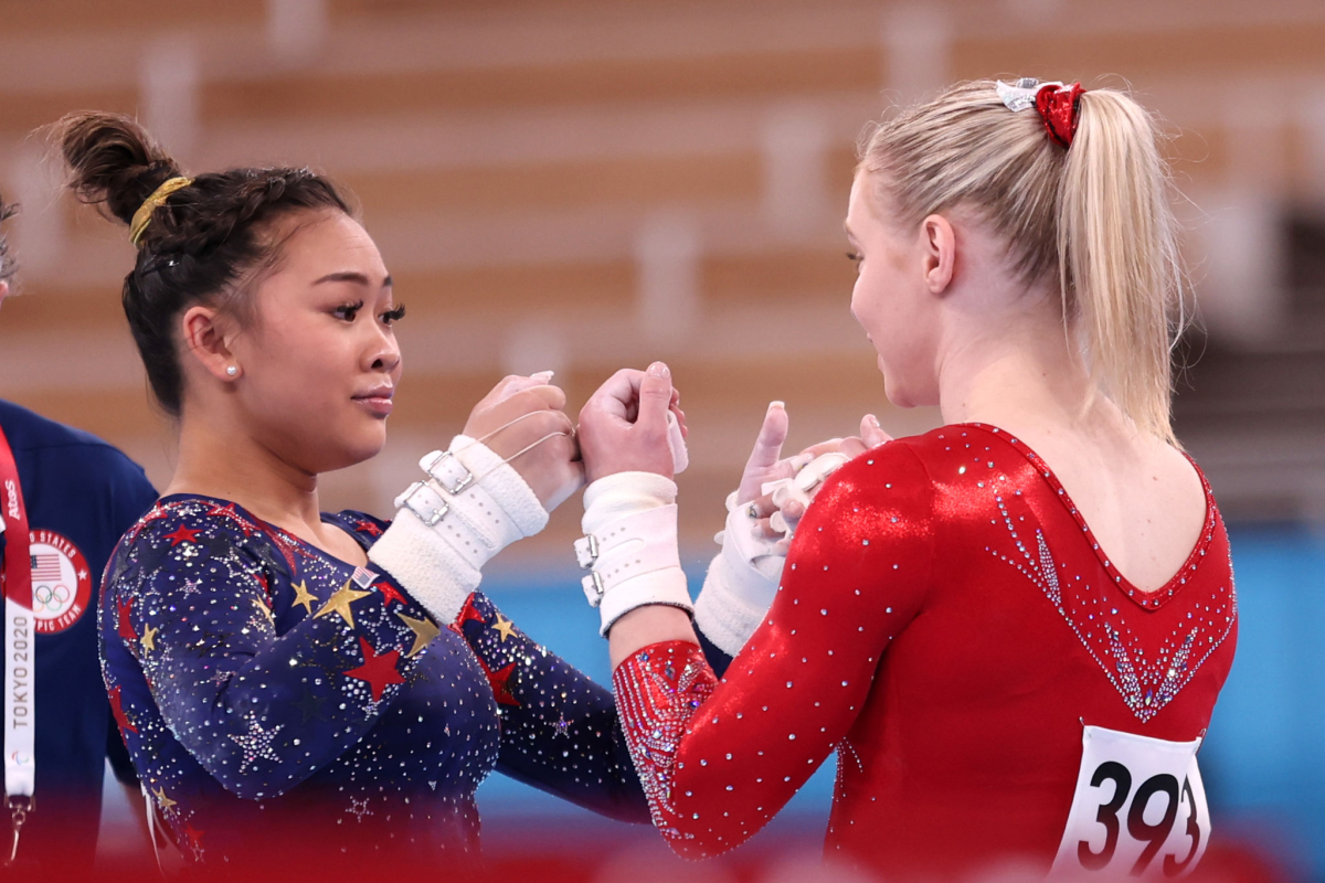 U.S. gymnasts Sunisa Lee, left, and Jade Carey fist bump during the qualification round at the Tokyo Olympics on Monday.