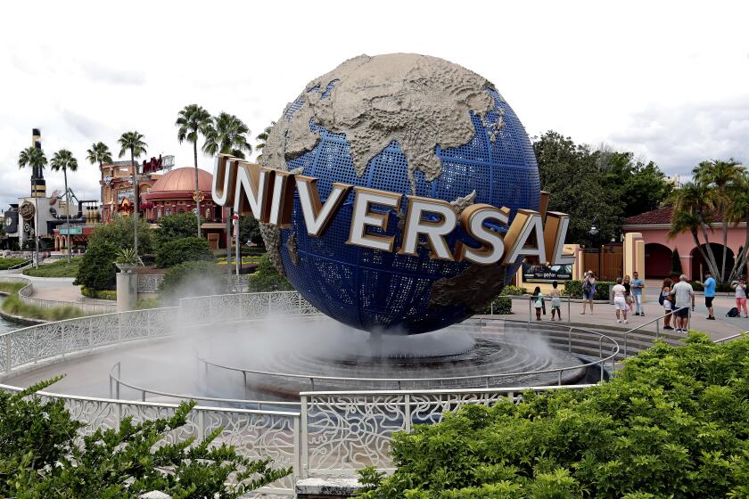 The giant, rotating Universal globe in a bed of fog surrounded by palm trees and other greenery