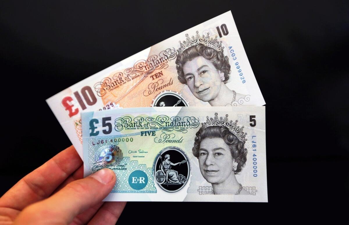 Samples of five- and 10-pound British polymer banknotes are displayed during a news conference at the Bank of England in London.
