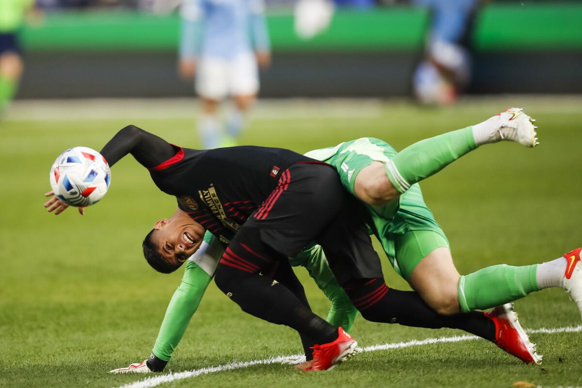 Atlanta United defender Alan Franco, front, and goalkeeper Brad Guzan (1) battle for the ball against New York City FC's Valentín Castellanos (not shown) during the first half of an MLS soccer match at Yankee Stadium, Sunday, Nov. 21, 2021, in New York. (AP Photo/Eduardo Munoz Alvarez)