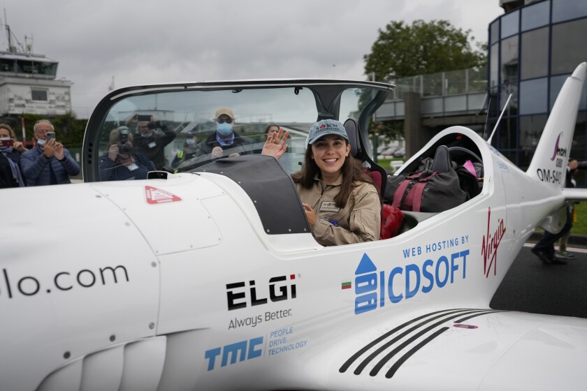 Belgian-British teenager Zara Rutherford waves from her Shark Ultralight airplane prior to take off at the Kortrijk-Wevelgem airfield in Wevelgem, Belgium, Wednesday, Aug. 18, 2021. A Belgian-British teenager took to the skies Wednesday in her quest to become the youngest woman to fly around the world solo. Nineteen-year-old Zara Rutherford took off from an airstrip in Wevelgem, Belgium, in an ultralight plane looking to break the record set by American aviator Shaesta Waiz, who set the world benchmark at age 30 in 2017. (AP Photo/Virginia Mayo)