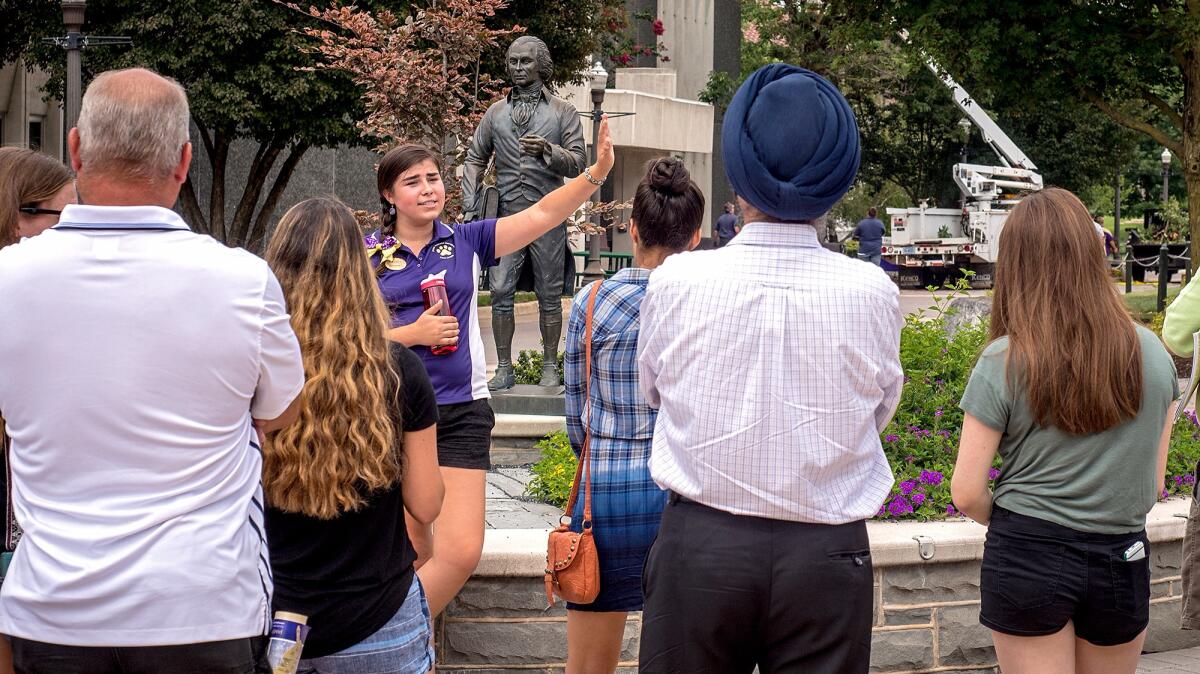 A James Madison University tour guide leads a group of prospective high school students around campus on Aug. 1 in Harrisonburg, Va.