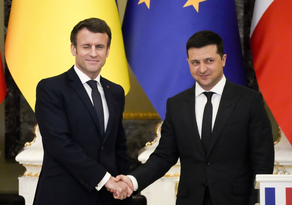 French President Emmanuel Macron shakes hands with Ukrainian President Volodymyr Zelenskyy after a news conference in Kyiv.