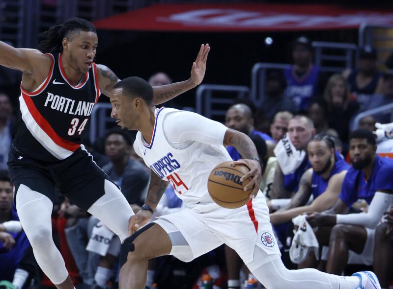 Los Angeles, CA - December 11: LA Clippers guard Norman Powell, right, dribbles past Trail Blazers.