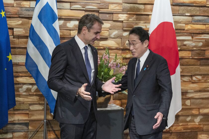 Greek Prime Minister Kyriakos Mitsotakis, left, is welcomed by Japanese Prime Minister Fumio Kishida upon his arrival ahead of their meeting at the prime minister's official residence in Tokyo on Monday, Jan. 30, 2023. (Richard A. Brooks/Pool Photo via AP)