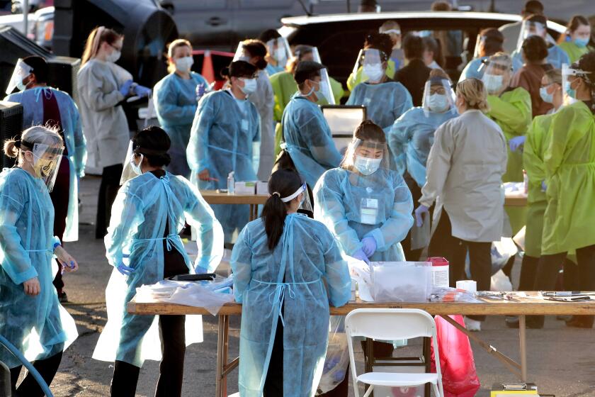 FILE - In this June 27, 2020, file photo, medical personnel prepare to test hundreds of people lined up in vehicles in Phoenix's western neighborhood of Maryvale for free COVID-19 tests organized by Equality Health Foundation, which focuses on care in underserved communities. By early June, just a few weeks after man coronavirus-related restrictions were lifted, cases began spiking. Arizona has seen its cases quintuple from 13,000 on May 15 to 74,500 on Monday, and deaths from the virus have nearly doubled in the last six weeks. More than 1,500 people have died. (AP Photo/Matt York, File)