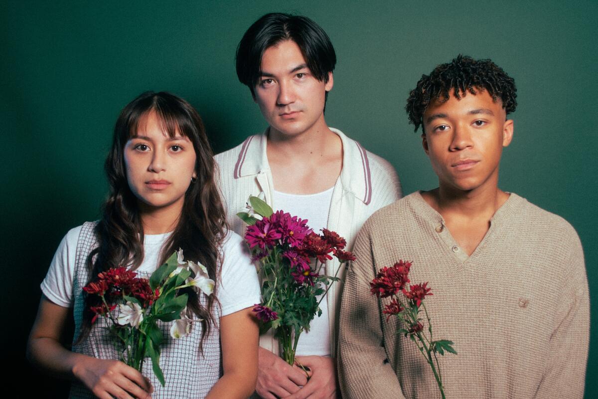 Three teenagers holding flowers