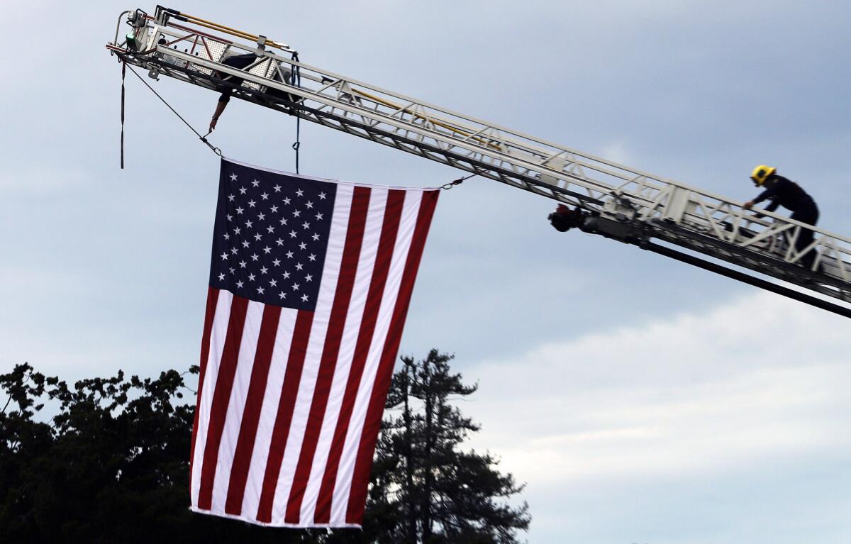 Orange County Firefighters raise the U.S. flag for the Walk to Remember Memorial service.