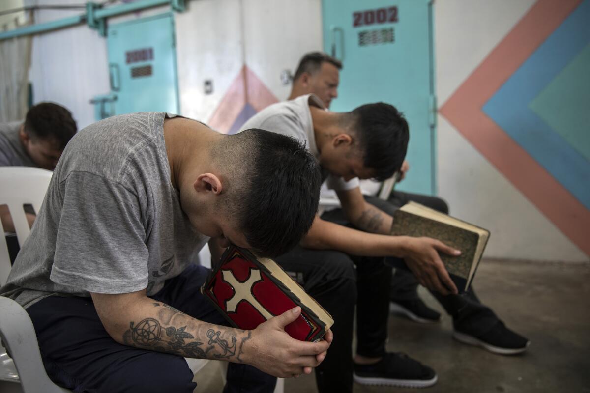 Presos rezan con sus Biblias dentro de un pabellón evangélico en la prisión de Piñero, provincia de Santa Fe, Argentina.