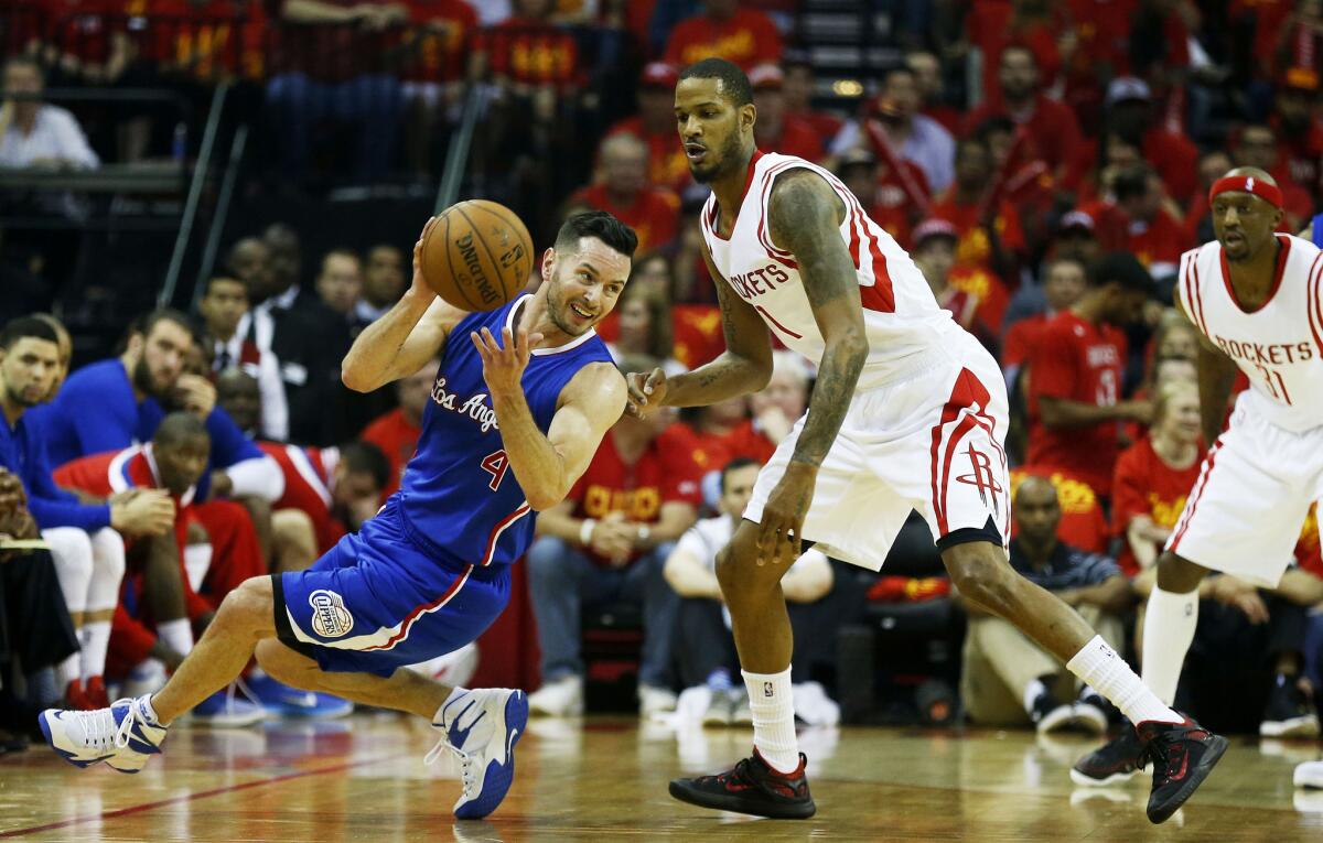 Clippers guard J.J. Redick tries to make a pass while losing his balance against Rockets forward Trevor Ariza in the first half.