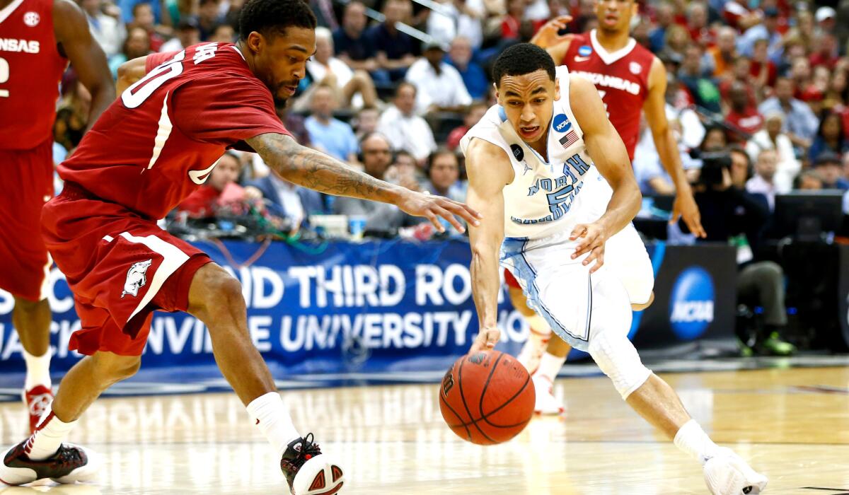 North Carolina guard Marcus Paige (5) tries to keep control of his dribble as he drives against Arkansas guard Rashad Madden in the second half during the Tar Heels' 87-78 victory over the Razorbacks on Saturday.
